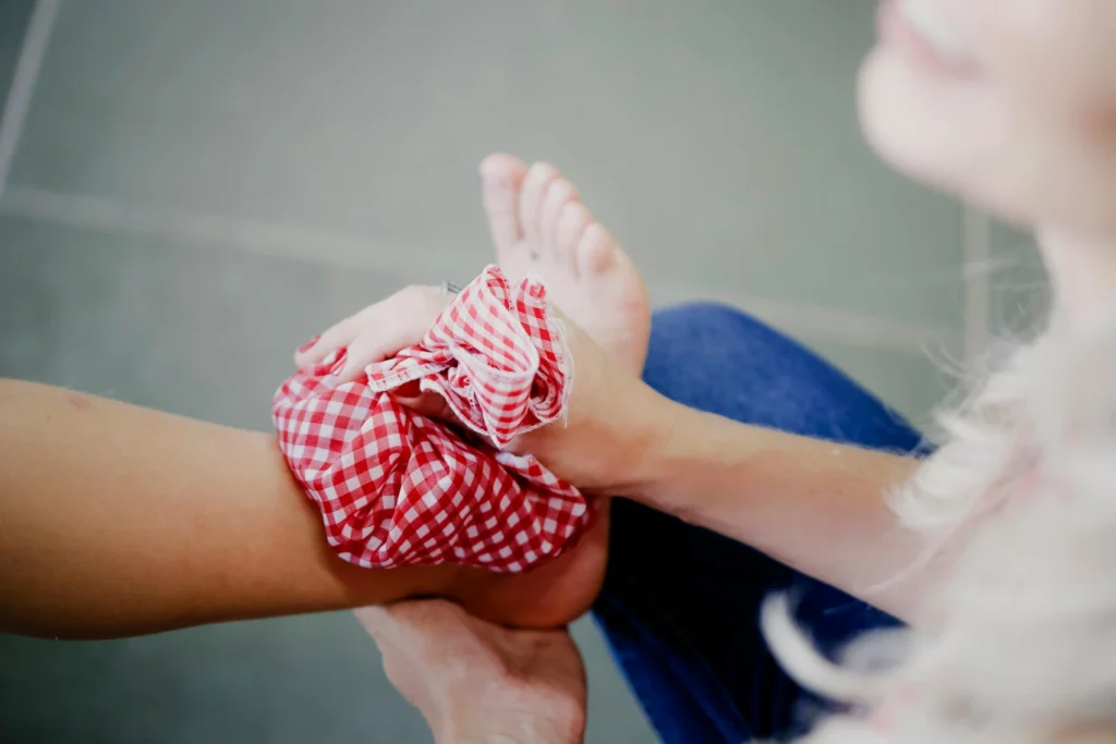 A picture of somebody holding an ice pack on an injured ankle.