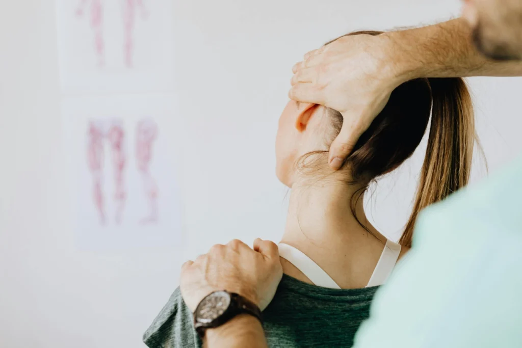 A woman having her neck examined by a doctor