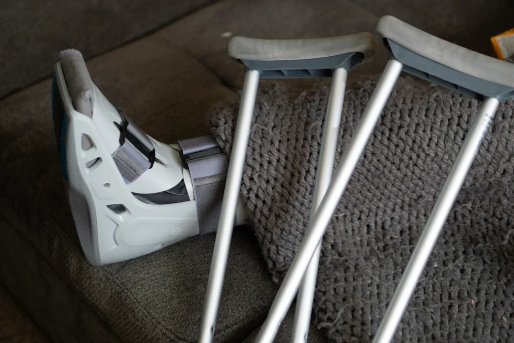 A picture of a pair of crutches laid across a leg in a bed